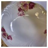 Collection of vintage porcelain and glass dishes, featuring various floral patterns, gilded rims, and crystal designs.