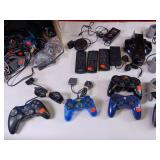 Collection of vintage video game accessories and plug-and-play consoles including PlayStation 2 and PlayStation 1 controllers