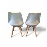 modern dining side chair design, often featuring a white plastic shell seat, a foam-filled cushion, and sturdy wood legs.