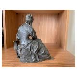 Bronze-colored seated woman figure...