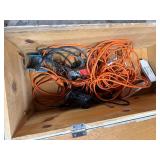 Wood box with electrical cords, battery tender and power strip.