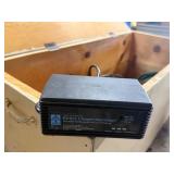 Wood box with electrical cords, battery tender and power strip.