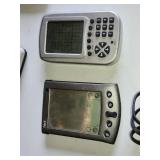 Various Vintage Electronic Gadgets Including Palm V PDA, Pocket Keno Game, and Other Handheld Devices