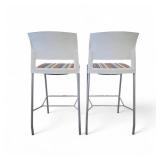 Steelcase Move bar stools featuring a white plastic back, a striped upholstered seat, and a four-leg metal frame.