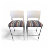Steelcase Move bar stools featuring a white plastic back, a striped upholstered seat, and a four-leg metal frame.