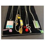 Assorted Silver-Tone Pendant Necklaces with Charms, Beads & Keys in Display Case