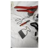 Vintage Kitchen Utensil Collection including Potato Ricer, Rolling Pin, and Hand Mixer