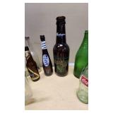 Collection of Vintage Beverage Bottles and Cans Including Miller, Schlitz, 7-Up, and Coca-Cola