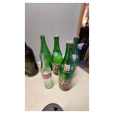 Collection of Vintage Beverage Bottles and Cans Including Miller, Schlitz, 7-Up, and Coca-Cola