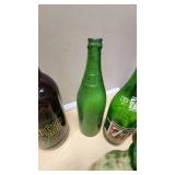 Collection of Vintage Beverage Bottles and Cans Including Miller, Schlitz, 7-Up, and Coca-Cola