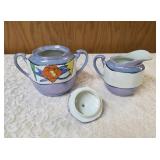 Vintage Art Deco Japanese Lusterware creamer and sugar bowl set.  Features a hand-painted iridescent glaze with a stylized abstract floral or geometric pattern.  Produced in Japan likely between 1921-