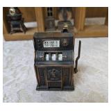 Vintage wood wall hanging shelf featuring a decorative heart cutout and die-cast metal collectibles. Cello, wagon, scale, slot machine, grandfather clock, stove which are pencil sharpeners and a cream