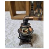 Vintage wood wall hanging shelf featuring a decorative heart cutout and die-cast metal collectibles. Cello, wagon, scale, slot machine, grandfather clock, stove which are pencil sharpeners and a cream