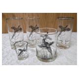 Five vintage barware glasses from the Federal Glass "Sportsman" Game Bird series, which typically features wildlife graphics and silver or gold rims.
