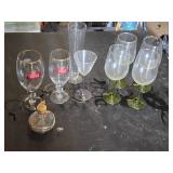 Mixed glassware including Stella Artois glasses, wine glasses with green stems, and a decorative bottle with a crown top.