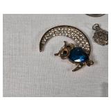 Assorted Jewelry and Pins including Brooches, Medallions, and Charms