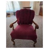 Vintage upholstered armchair featuring a carved wood frame