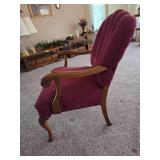 Vintage upholstered armchair featuring a carved wood frame