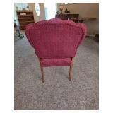 Vintage upholstered armchair featuring a carved wood frame