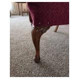 Vintage upholstered armchair featuring a carved wood frame