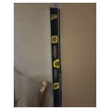a level tool, pipe wrench, and a long wooden stick leaning