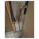 a level tool, pipe wrench, and a long wooden stick leaning