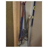 a level tool, pipe wrench, and a long wooden stick leaning