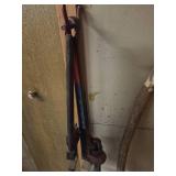 a level tool, pipe wrench, and a long wooden stick leaning