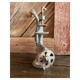 Cast iron hand-crank meat grinder.