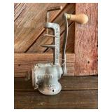 Cast iron hand-crank meat grinder.