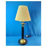 Vintage table lamp featuring a brass and black column with a pleated shade.
