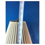 Vintage table lamp featuring a brass and black column with a pleated shade.
