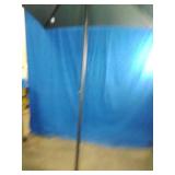 Brand New  Market Patio Umbrella. It features a dark colored canopy supported by a multi-rib metal frame structure