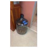 Glass gallon jug with pennies.