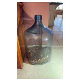 Glass gallon jug with pennies.