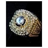 Brand New This is a men’s Pinky Ring yellow gold-plated ring featuring a large center stone surrounded by smaller simulated diamonds. Size 7