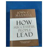 Collection of six self-improvement, financial literacy, leadership, and communication books laid out on a blue fabric surface.