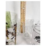 Vintage Decorative Glassware Including Flintstones and Animal Designs, Green Patterned Glasses, and Clear Glass Sets