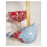 Assorted Glass and Ceramic Home Decor Items including Red Glass Compote, Blue Rooster Figurine, and Heart-Shaped Plate with Religious Image