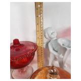 Assorted Glass and Ceramic Home Decor Items including Red Glass Compote, Blue Rooster Figurine, and Heart-Shaped Plate with Religious Image