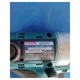 Makita 6337D 14.4V cordless tool set featuring teal-colored drills and a matching charger.