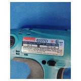 Makita 6337D 14.4V cordless tool set featuring teal-colored drills and a matching charger.
