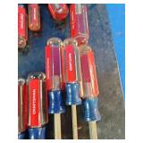 Craftsman acetate-handle screwdrivers mounted on a storage rack organizer.