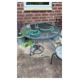 Two outdoor glass tabletop tables, one side table, one full table, and umbrella stand.
