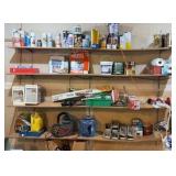 Contents of wooden shelves, including:- various paints- gloss trim- Wheaties box- board games- decorative outdoor lighting- tools- vacuum- mini shop back