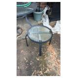 Two outdoor glass tabletop tables, one side table, one full table, and umbrella stand.