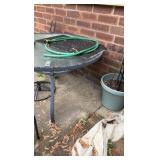 Two outdoor glass tabletop tables, one side table, one full table, and umbrella stand.