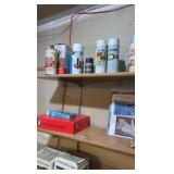 Contents of wooden shelves, including:- various paints- gloss trim- Wheaties box- board games- decorative outdoor lighting- tools- vacuum- mini shop back