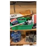 Contents of wooden shelves, including:- various paints- gloss trim- Wheaties box- board games- decorative outdoor lighting- tools- vacuum- mini shop back