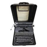 vintage Royal Quiet De Luxe portable typewriter from the 1930s or 1940s, enclosed in its original black metal carrying case.